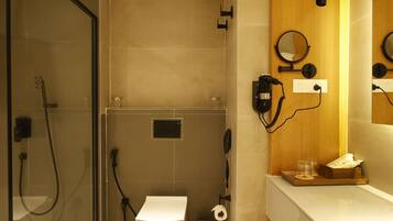 Une salle de bain moderne dotée d’une douche à parois de verre, de toilettes et d’un meuble-lavabo avec un miroir.
