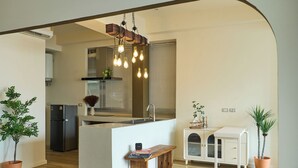 A modern kitchen with a central island, pendant lighting, and a small bench. - 5loft Anti-Hotel, Silom, Bangkok (Bangkok)