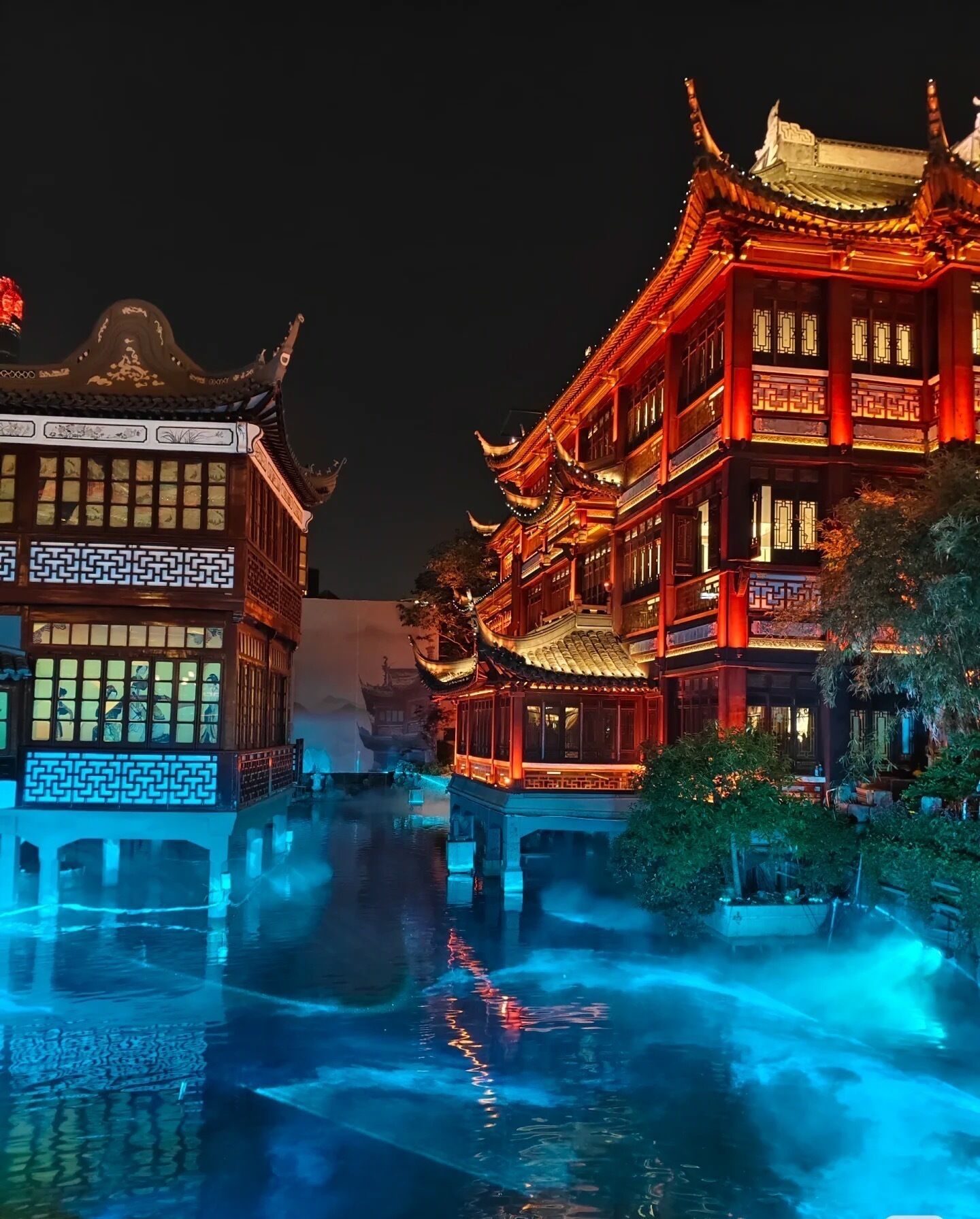 A traditional Chinese building with ornate architecture and a water feature in front.