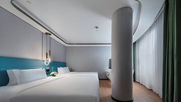 Een moderne hotelkamer met een groot bed, een bureau en uitzicht op de stad.