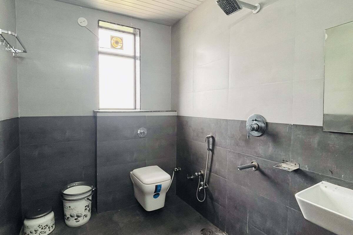 A bathroom with a toilet, sink, and shower.