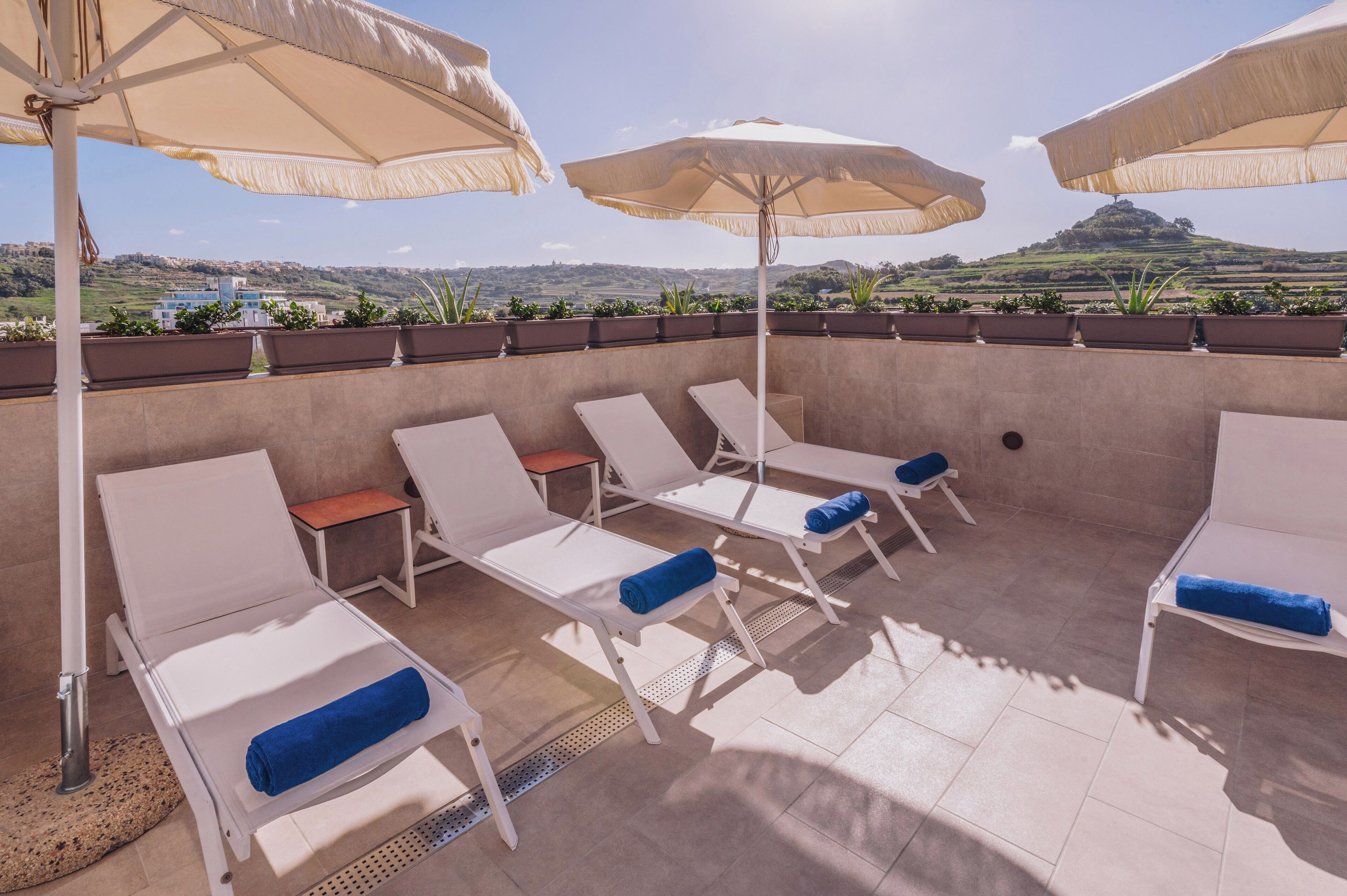 Una piscina techada, una piscina al aire libre, sombrillas