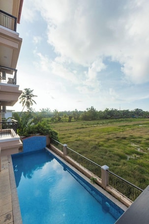 Una piscina al aire libre, sillones reclinables de piscina