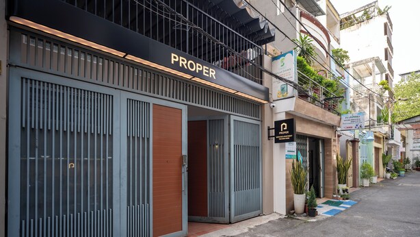 Un edificio con escaparate identificado como "PROPER" y un letrero que dice "5 LAUNDRY".