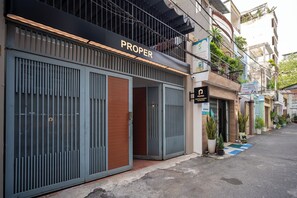 A building with a storefront labeled "PROPER" and a sign for "5 LAUNDRY". - Proper Serviced Apartment Tao Đàn Park (Ho Chi Minh City)