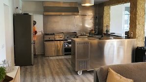 A modern kitchen with stainless steel appliances, a central island, and a dining area with a sofa. - Villa 'Dehesa' with Mountain Views, Wi-Fi, and Air Conditioning (Tabernas)