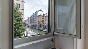 A view from a window overlooking a canal with buildings and a bridge.