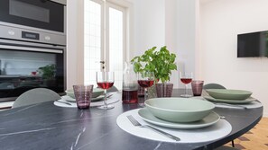 Ett modernt kök med en svart bänkskiva, en inbyggd ugn och ett stort fönster.