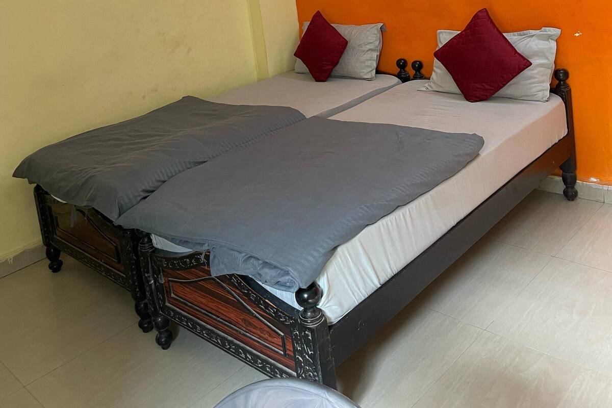 Een slaapkamer met een bed, een plafondventilator en een wandlamp.
