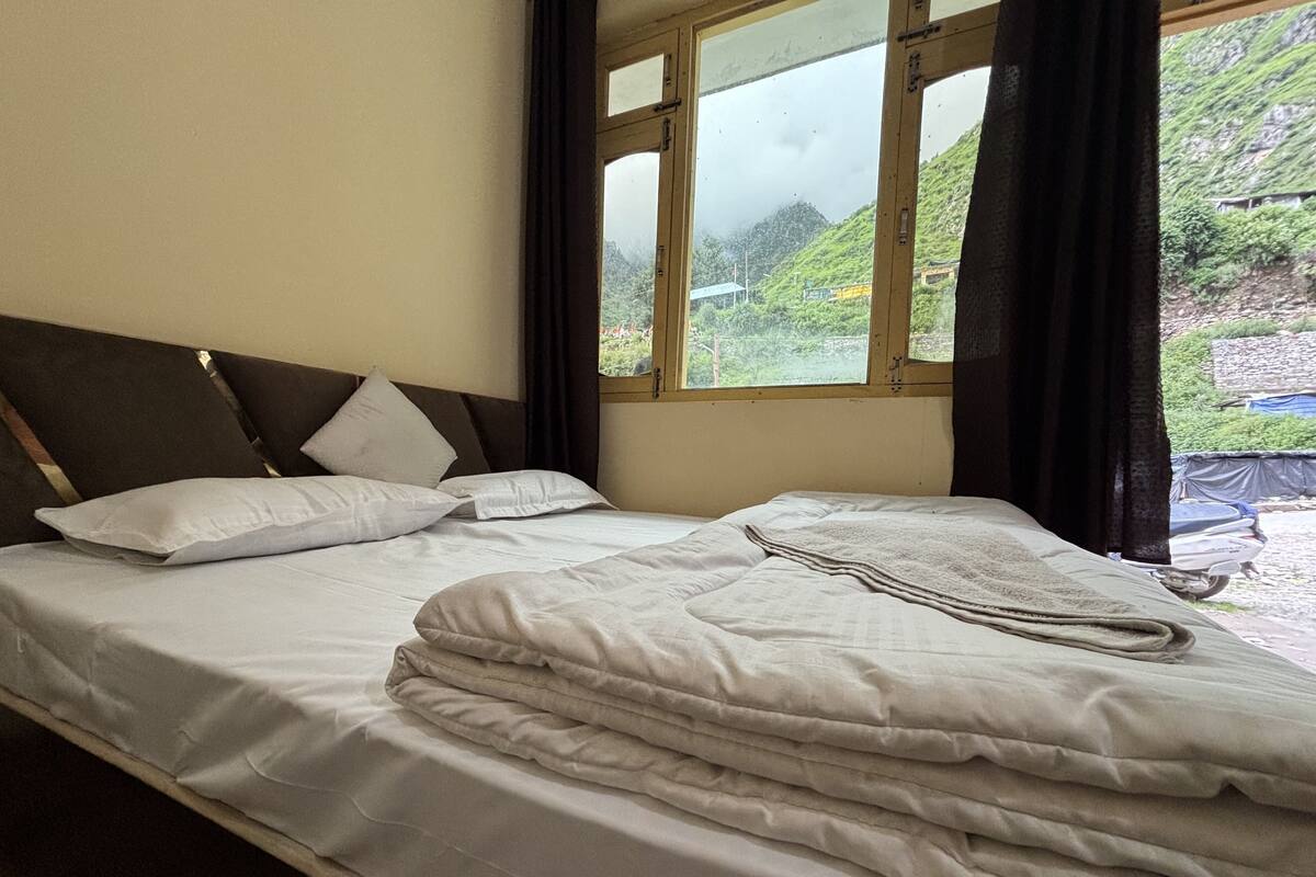 Una cama con cabecera, almohadas y una manta.