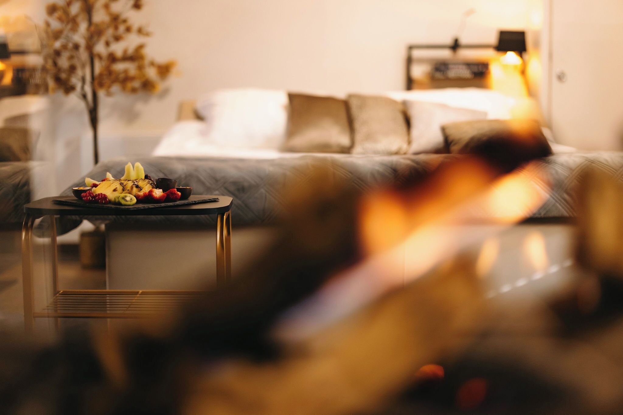 Ein gemütliches Wohnzimmer mit einer Couch, einem Couchtisch mit Früchten und einem Kamin.