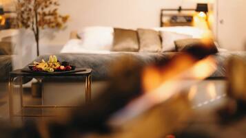 Ein gemütliches Wohnzimmer mit einer Couch, einem Couchtisch mit Früchten und einem Kamin.