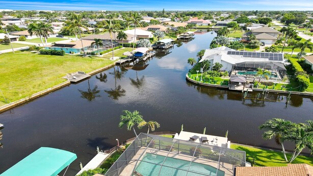 A residential area with a canal, houses, and a swimming pool.