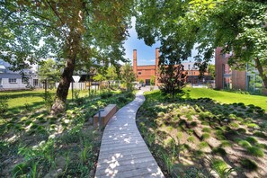 A pathway leading to a building with brick architecture and a green lawn.