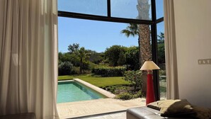 A room with a large window overlooking a swimming pool and a garden. - EXCEPTIONAL VILLA - GOLF - SWIMMING POOL - BREAKFAST AND SERVICES (essaouira)