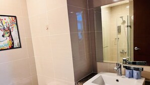 Ein modernes Badezimmer mit einem weißen Waschbecken, einer Glasdusche und einer Toilette.