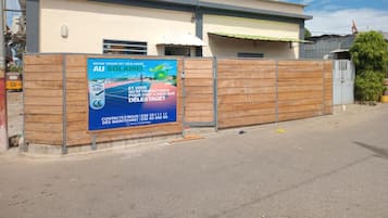 Un edificio residencial con valla de madera y un gran anuncio lateral.