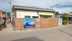 Un bâtiment entouré d’une clôture en bois et sur lequel est affichée une enseigne publicitaire pour un service.