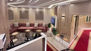 Un soggiorno moderno con un divano componibile, un tavolo da pranzo e una TV a parete.