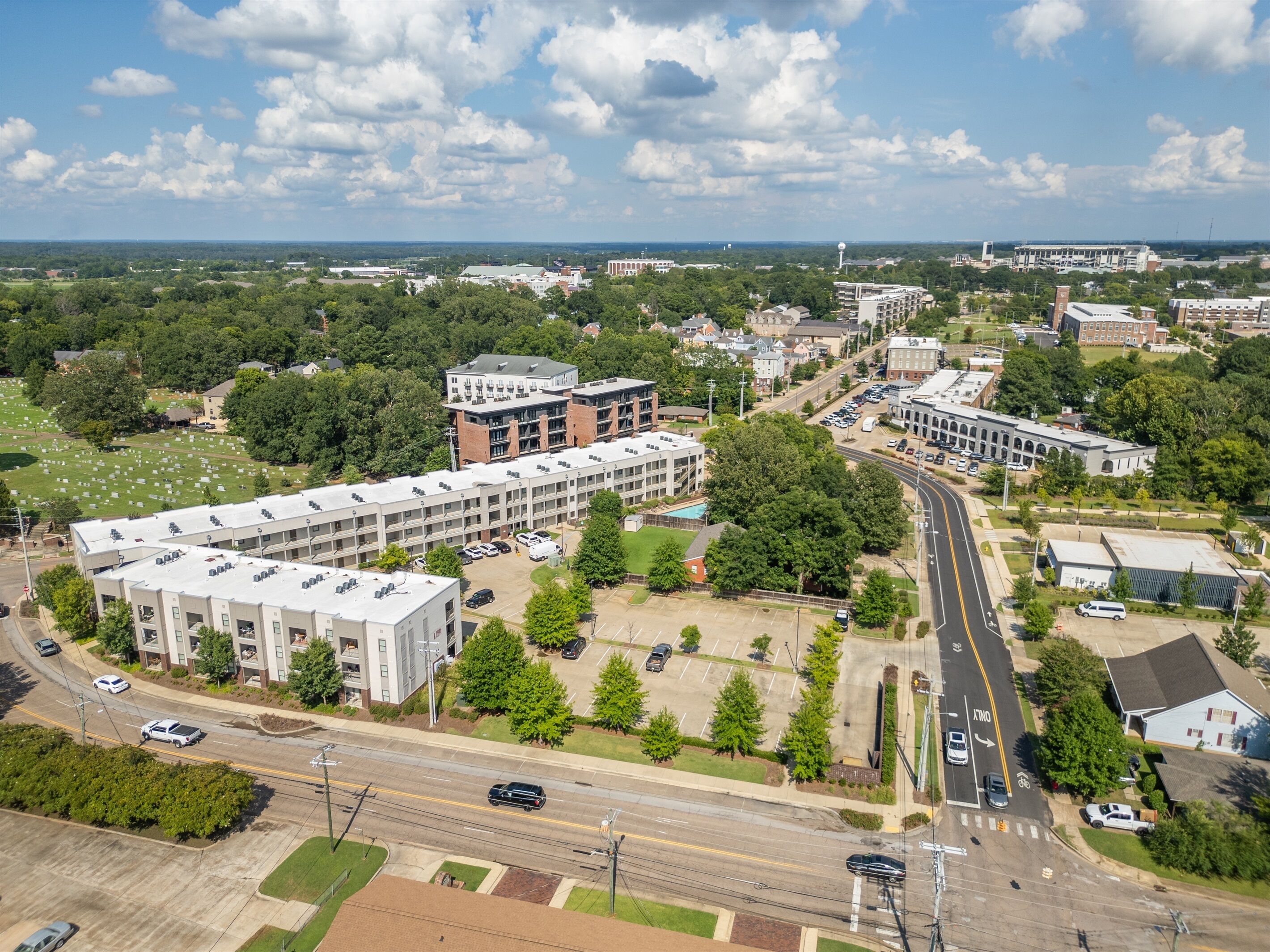 An aerial view of a campus with multiple buildings, roads, and green spaces.