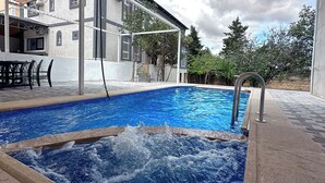 Piscina com deck de madeira e área coberta.