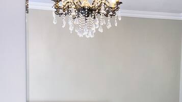 A bedroom with a bed, a chair, and a chandelier.