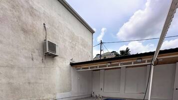 A swimming pool with a tiled deck and a concrete wall.