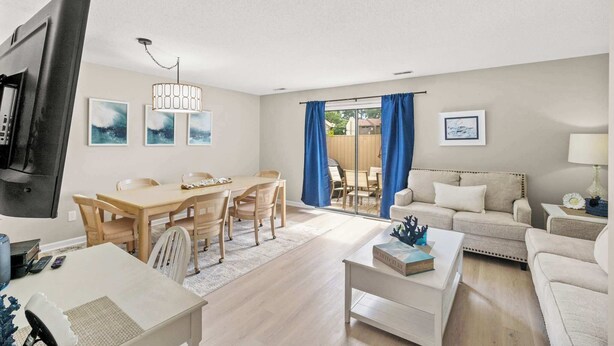 A modern living room with a TV, dining area, and a sofa.
