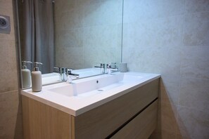 A modern bathroom with a double sink, a mirror, and a towel dispenser. - Superb duplex with sauna and swimming pool - at the foot of the slopes - Vars - top-of-the-range services (Vars)