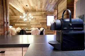A coffee machine on a counter in a room with wooden walls and a chandelier. - Superb duplex with sauna and swimming pool - at the foot of the slopes - Vars - top-of-the-range services (Vars)