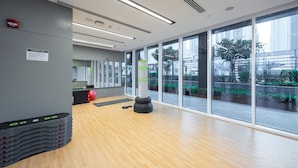 A modern gym with wooden flooring, large windows, and exercise equipment. - Astonishing 1 BR Apartment in Creek Harbour (Dubai)