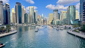 A marina with boats and a city skyline with modern high-rise buildings. - Spacious 3BR Marina Stay With City Views (Dubai)