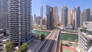 A high-rise building with a modern design, featuring multiple balconies and a river running alongside. - Spacious 3BR Marina Stay With City Views (Dubai)