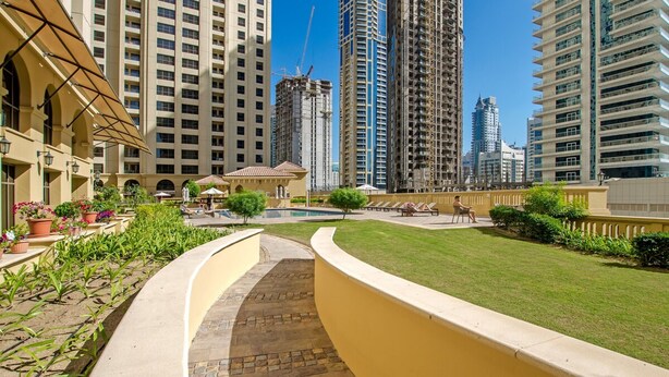Un patio con piscina, rodeado de edificios altos, algunos en construcción.