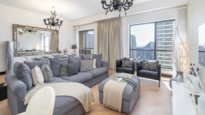 A modern living room with a grey sofa set, a black armchair, and a large mirror. - Great 2BR Apartment Near JBR Beach (Dubai)