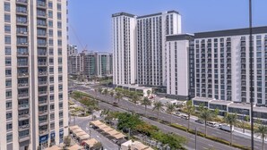A high-rise residential building with multiple balconies and a clear view of the surrounding urban area. - Chic 1BR Flat Stunning Views in Dubai Hills (Dubai)