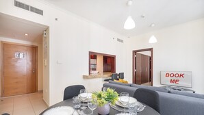 Un coin repas avec une table ronde dressée pour six personnes, un canapé et une pancarte indiquant « RÉSERVEZ-MOI ».