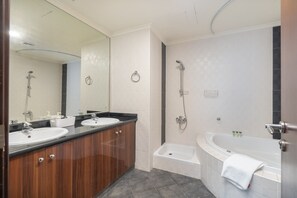 A modern bathroom with two sinks, a bathtub, and a shower. - Amazing 4-bedroom Apartment Perfect for Families in Dubai Marina (Dubai)