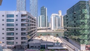 A modern urban area with high-rise buildings, a waterfront, and a variety of commercial establishments including a laundromat. - Amazing 4-bedroom Apartment Perfect for Families in Dubai Marina (Dubai)
