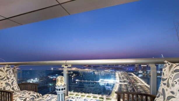 A balcony with a city view at dusk. - Scenic 2BR Near Beach in Princess Tower Marina (Dubai)