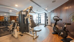 Ein modernes Fitnessstudio mit Cardiogeräten, Krafttrainingsgeräten und Kurzhanteln.