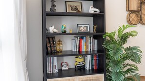 A bookshelf with decorative items and books. - Boho-inspired 1 bed in Production City (Dubai)