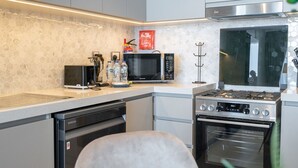 Een moderne keuken met een magnetron, fornuis, oven en vaatwasser.