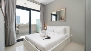 A modern hotel room with a large bed, a balcony with curtains, a city view, and a mirror on the wall. - Stylish 1-bedroom Apartment With Stunning Canal Views at Business Bay (Dubai)