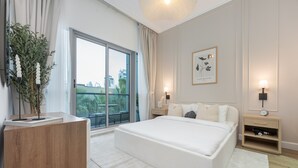 A modern bedroom with a large bed, a desk, and a view of the city through large windows. - Stylish 1BR Urban Living in Dubai Marina (Dubai)