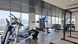 A gym with cardio equipment, weight machines, and dumbbells.