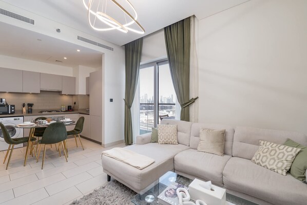 A modern apartment with a dining area, kitchenette, and a living room with a sofa and coffee table.