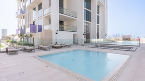 A rooftop pool area with lounge chairs and a large pool. - Gorgeous 1 Bedroom in Binghatti House and Sleeps 4 (Dubai)