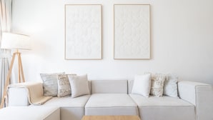 Ein modernes Wohnzimmer mit einer Couch, einem Couchtisch und zwei gerahmten Kunstwerken an der Wand.