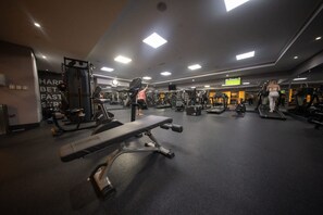 A gym with various exercise equipment, including treadmills, weight machines, and benches. - 1802 Goldcrest Views 2 (Dubai)